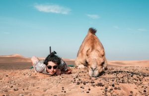 Read more about the article Resting in the Sands: Man and Camel under desert skies